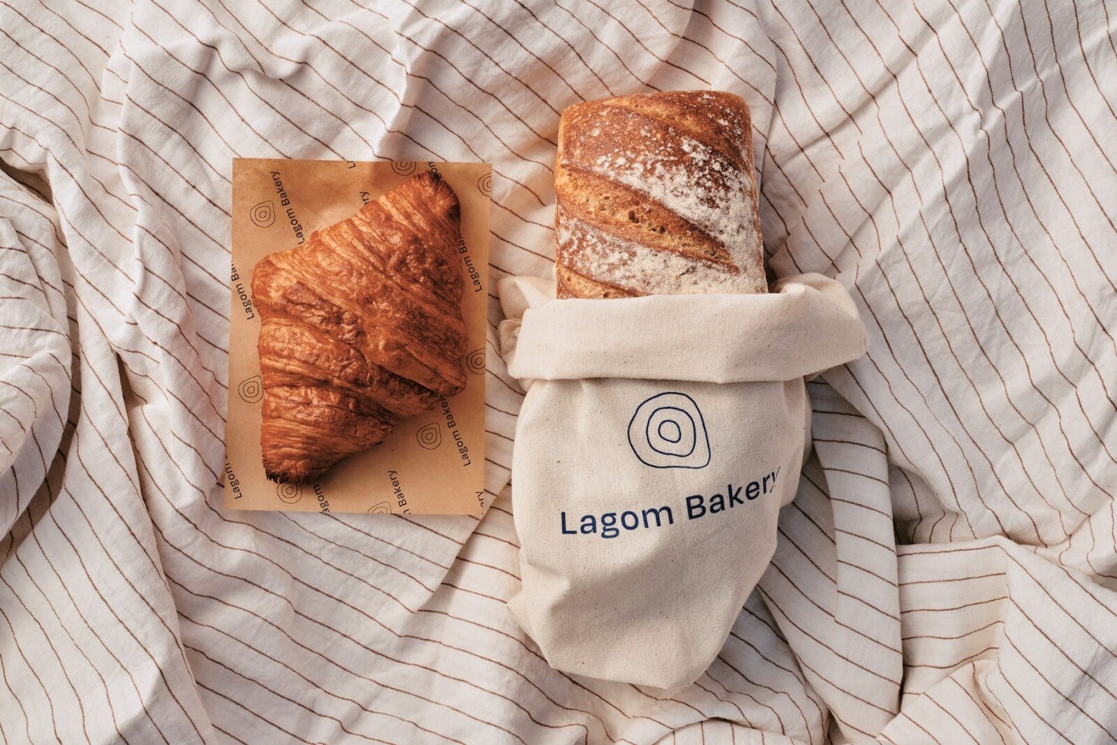 lagom bakery rustic white sourdough loaf and croissant on a linen spread