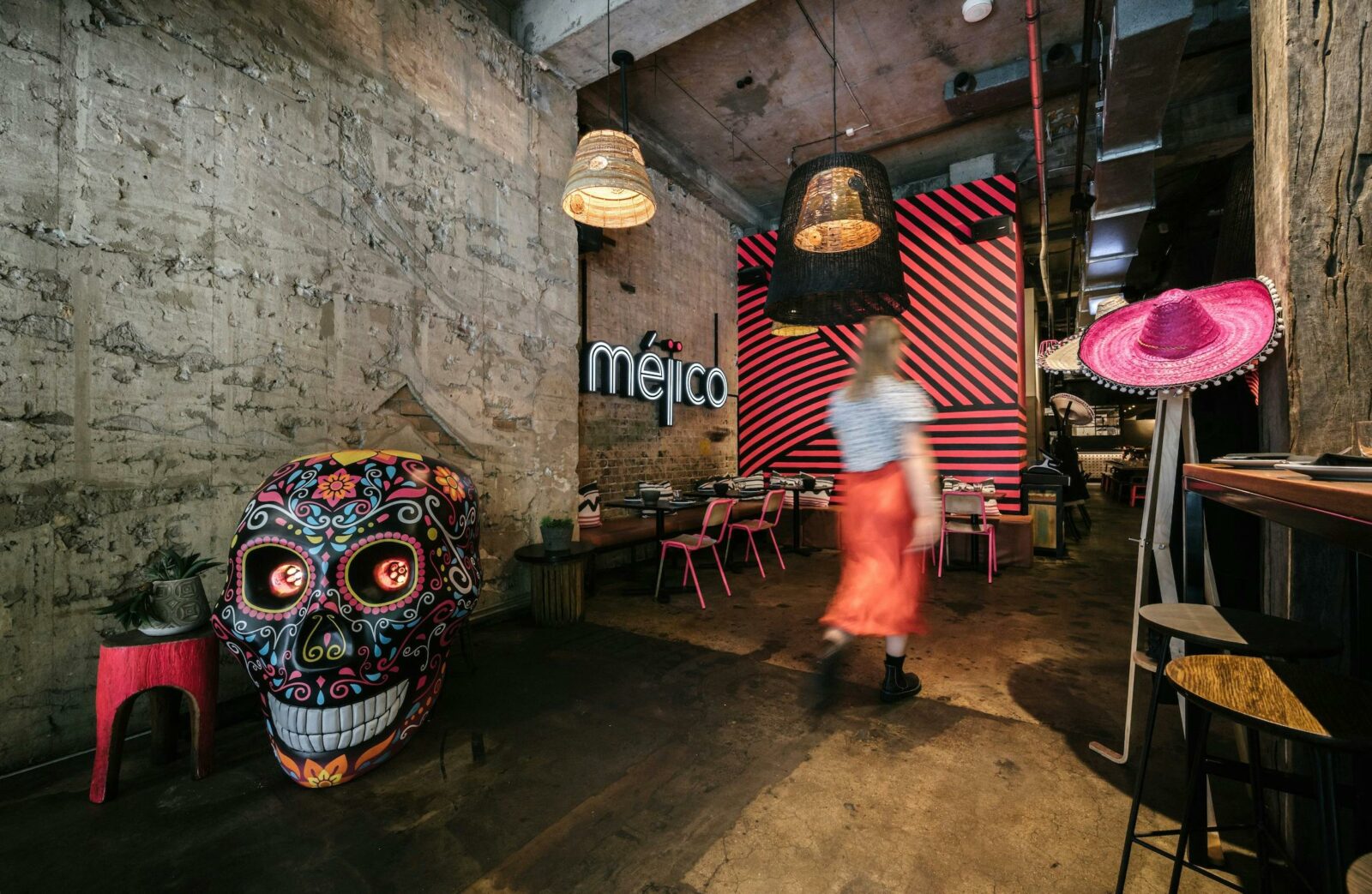 Blurred woman walking in front of large skull, into a restaurant