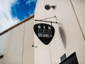 Six String Brewing Co sign hanging outside the brewery door