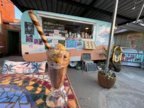Milkshake on table in front of retro caravan cafe The Yard at Narrandera NSW