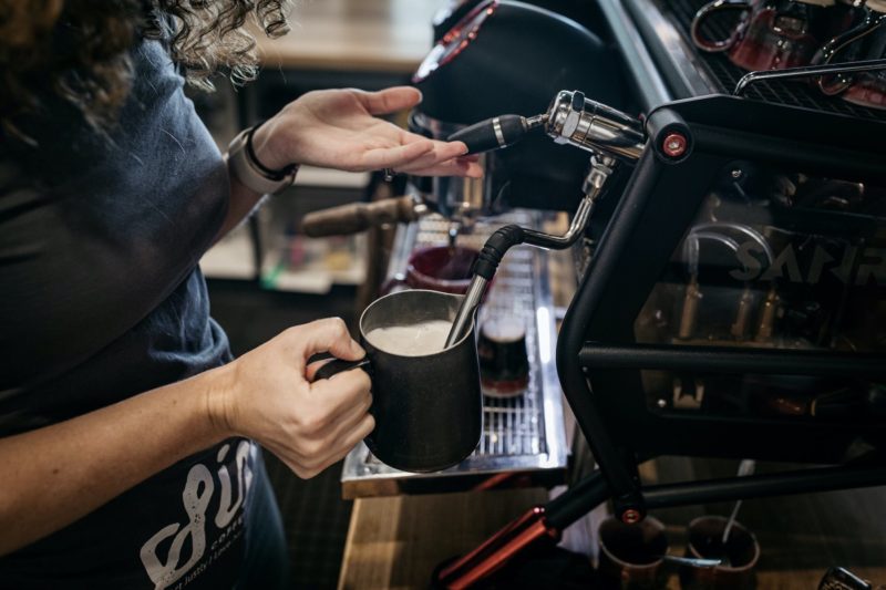 Trader & Co Barista serving award-winning, in-house roasted specialty Six8 Coffee.