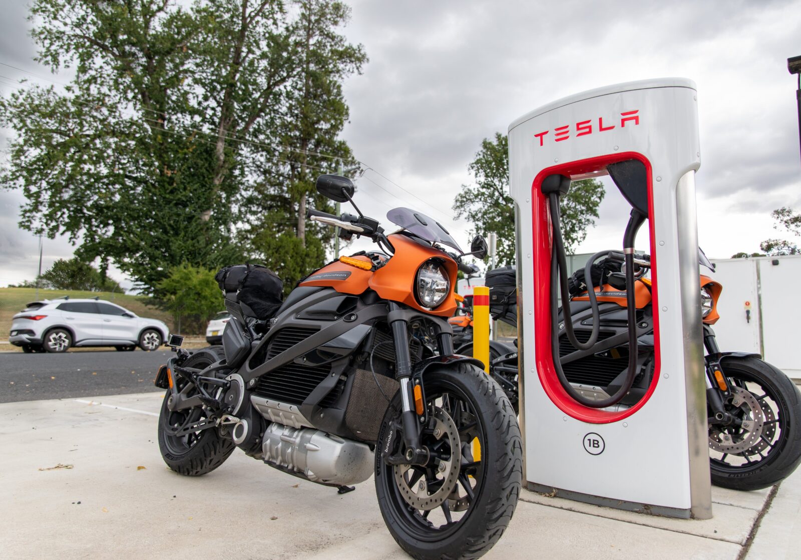 An electric Motorcycle charging at a Tesla Electric Vehicle Charger