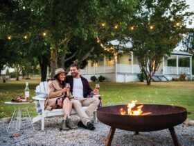 Couple sitting by fireplace enjoying glass of wine