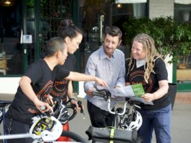 Bike instructors helping a bike rider navigate with a bike map of City of Sydney
