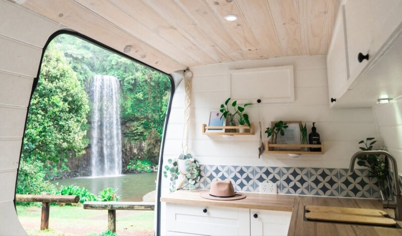 Dandy van looking out the door to the kitchenette and a waterfall outside