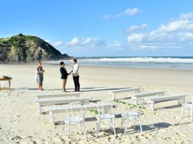 A couple saying their vows with the ocean in the background at Cosy Corner at Tallow Beach, Cape