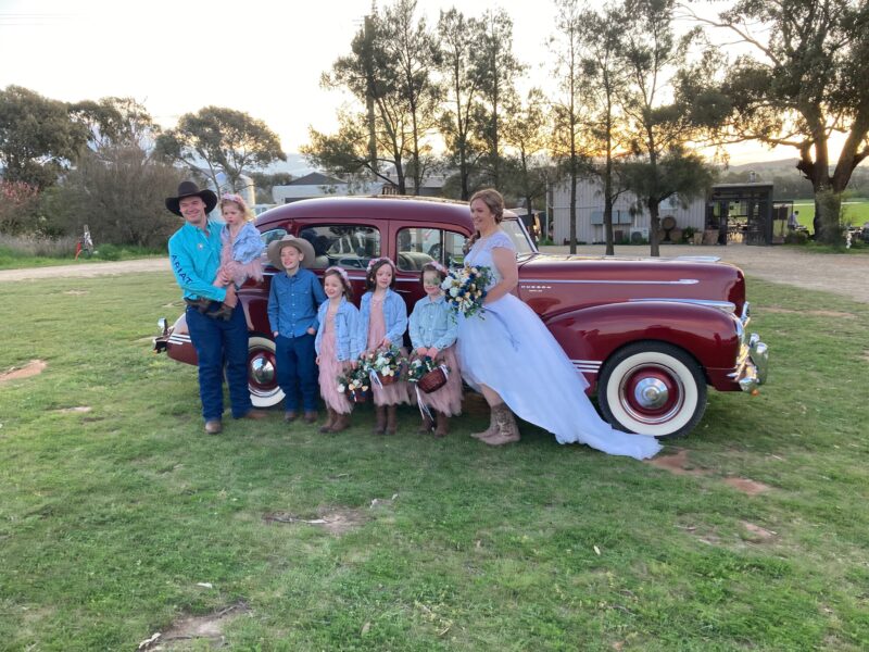 Brides family in front of red Car