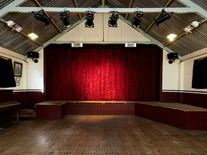 The interior of Royal Hall with the stage at the back, behind a red curtain in Hill End Historic