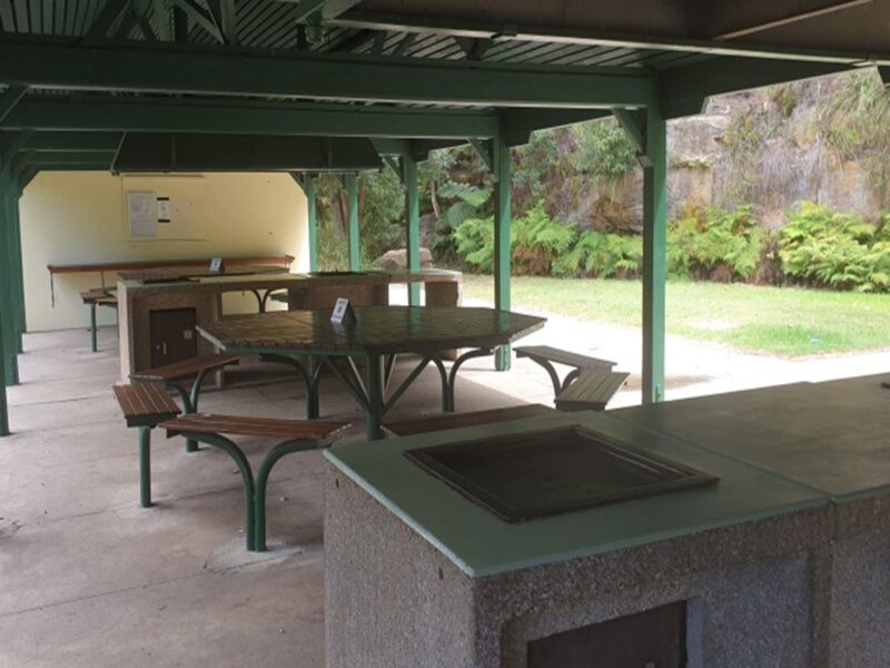 Picnic tables and a barbecue at The Station picnic shelter in Ku-ring-gai Chase National Park.
