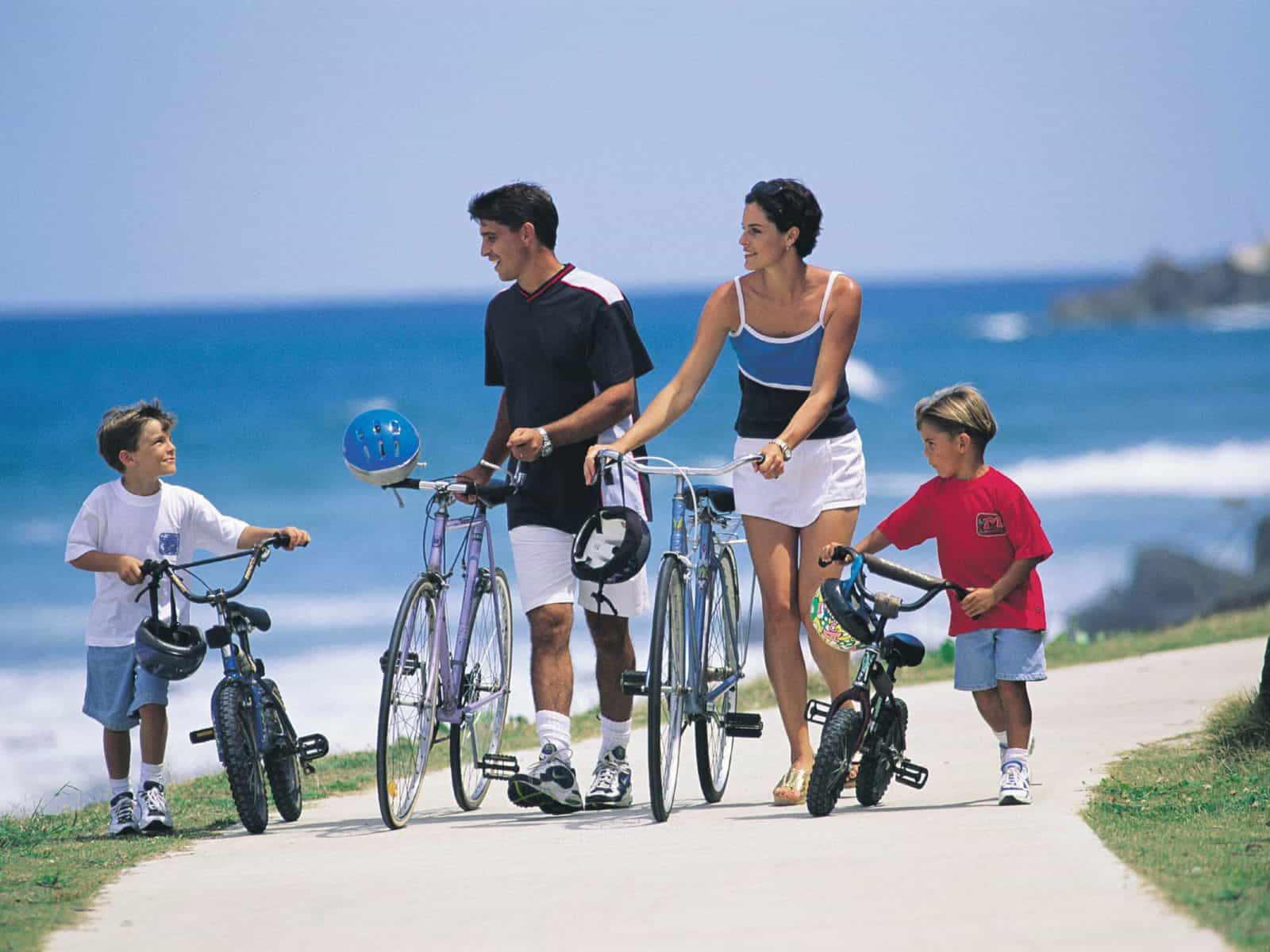 Family riding bikes along the coastline