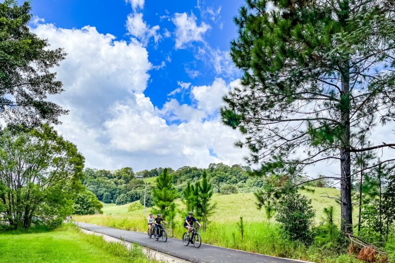 Three E Bike riders approaching viewer in nature at Stokers Siding on the Northern Rivers Rail Trail