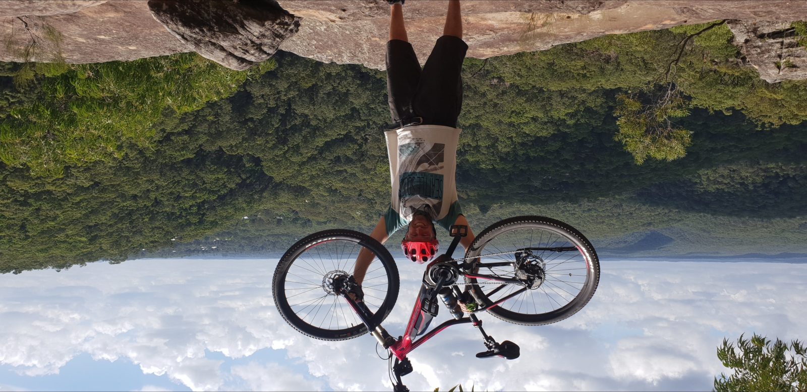 e-bike tour rider with bike held high over breathtaking view
