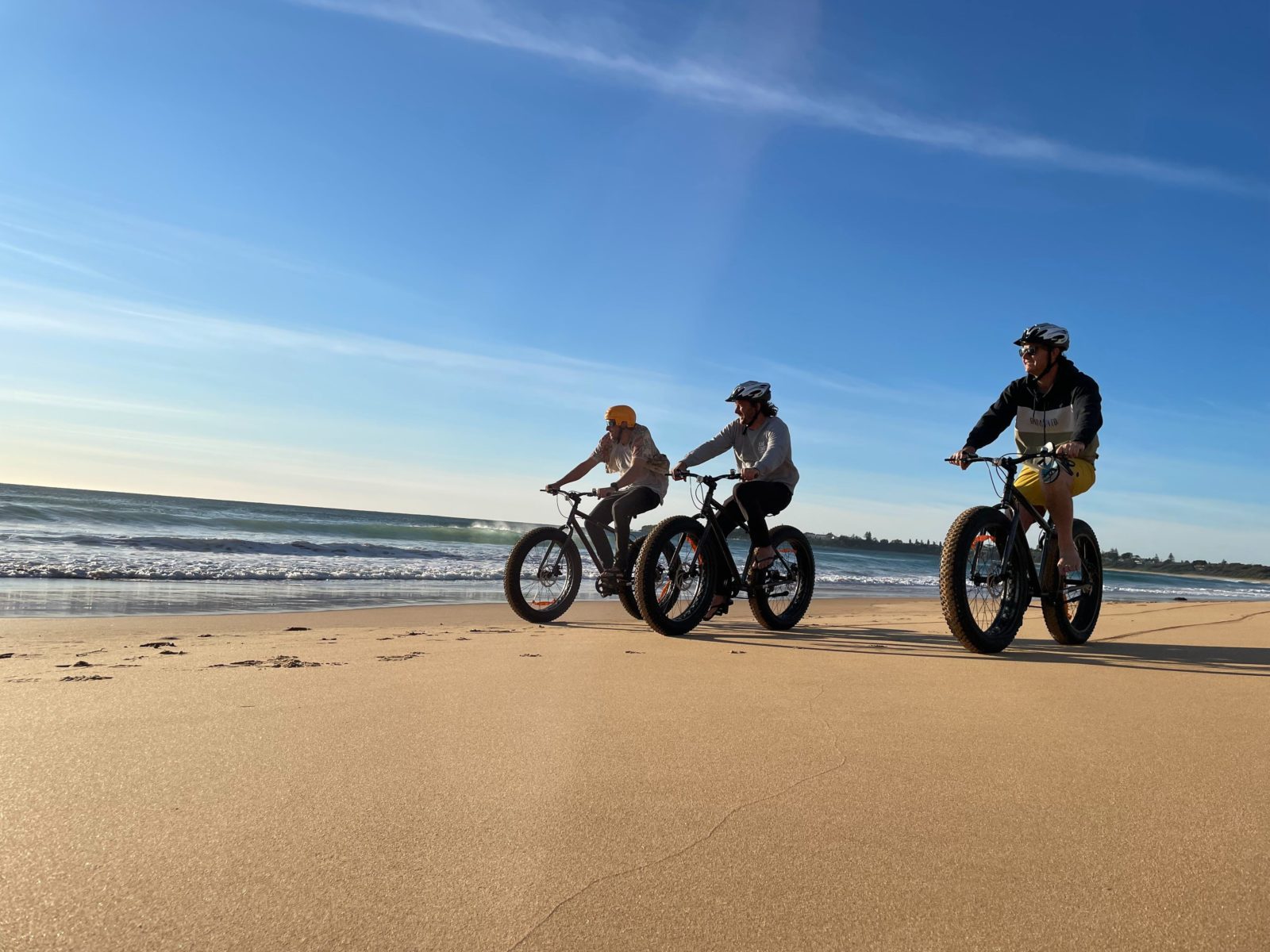Three bike riders on the beach