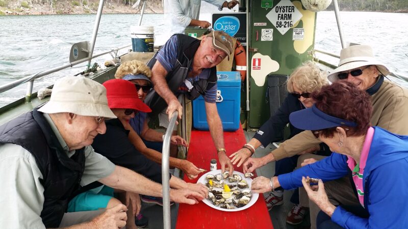 adults on small boat enjoying oysters