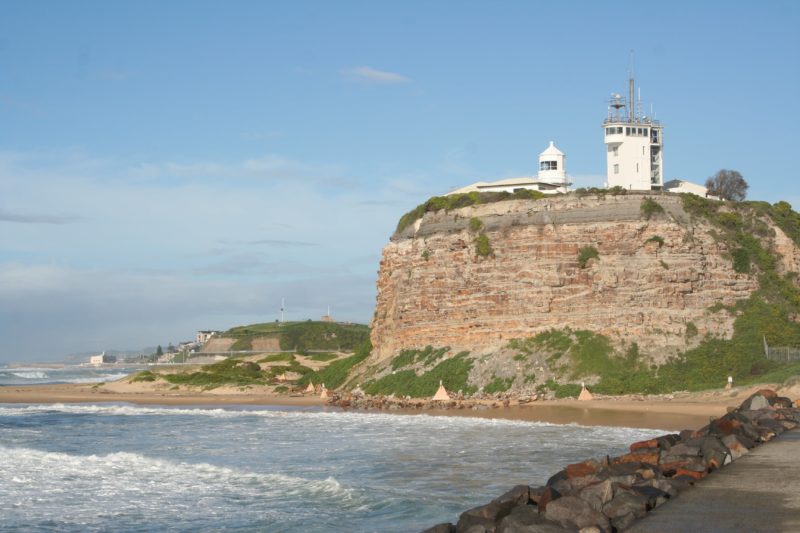 A headland in Newcastle with a lighthouse on top