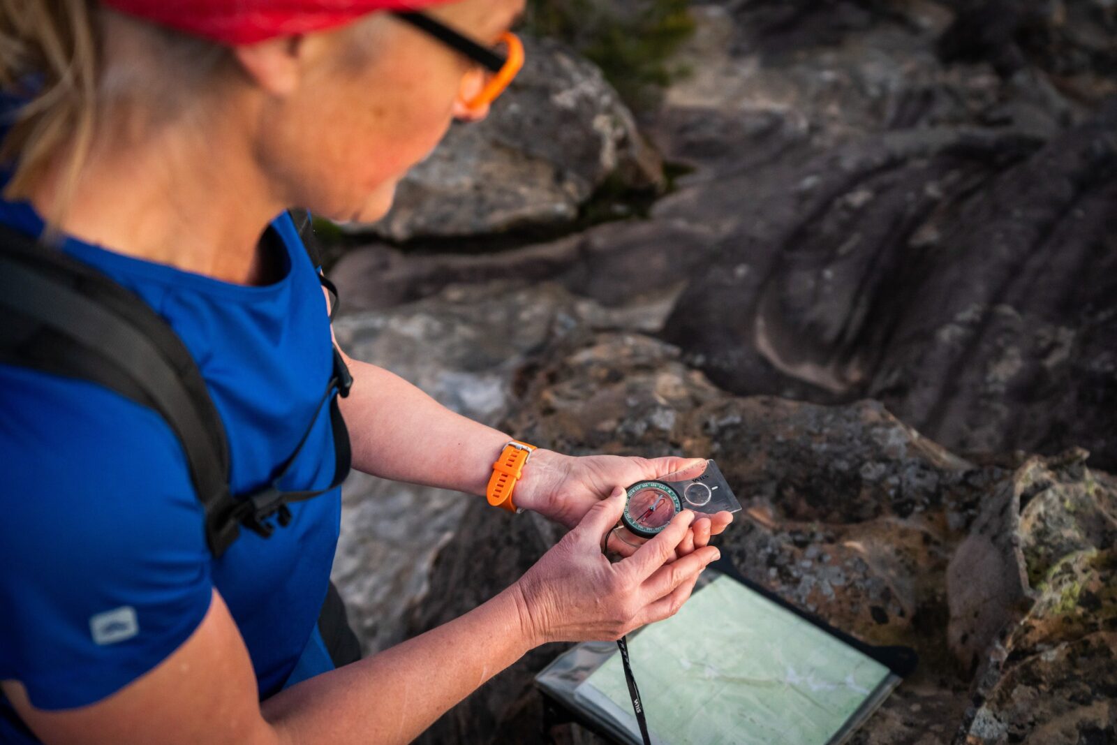 Woman adjusts compass with topographic map in background
