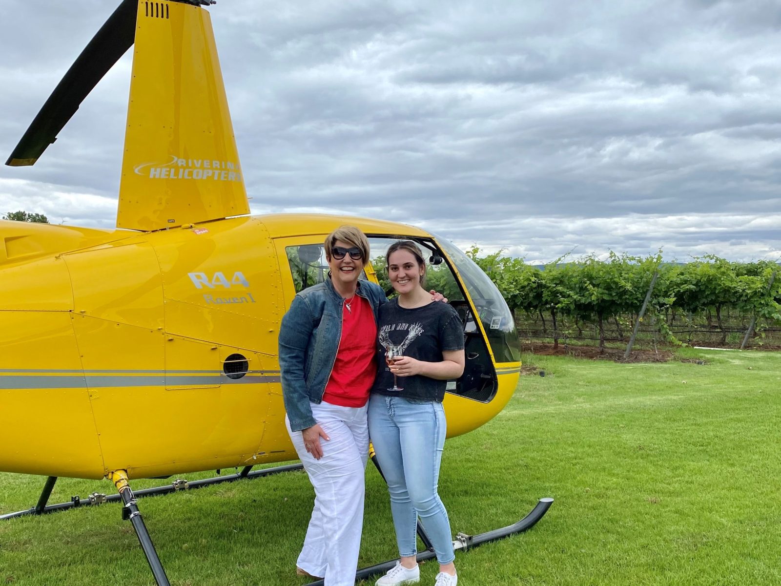 Two lovely ladies enjoying a glass of wine after arriving by helicopter in fron of a vineyard