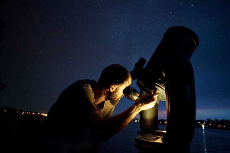 Man looking through a high powered telescope
