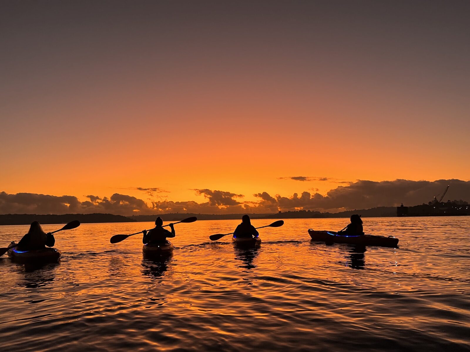 kayakers enjoying the first glowing orange rays of the sun