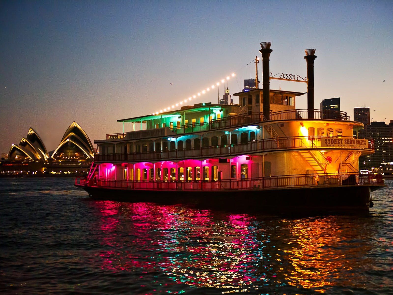 Vessel lit up on the harbour with Opera house in the background