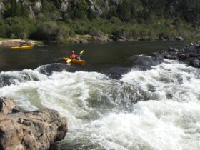 A nervous kayaker lines up on a rapid during the Walking Rivers Snow River, two other Kayaks waiting