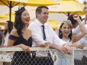 Group of people cheering while standing at a fence at the Alice Springs Turf Club