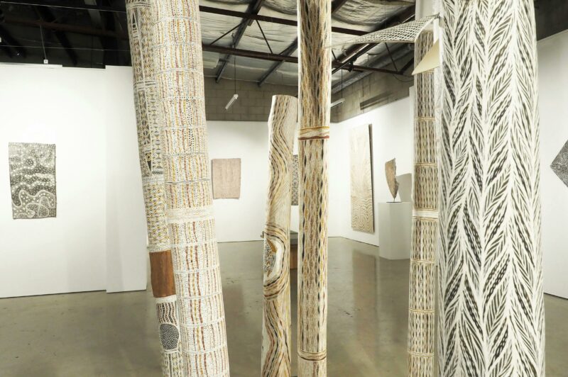Detail image of larrakitj and bark paintings install at praxis ART SPACE, in Adelaide SA