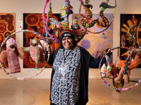 Luritja artist Rhonda Sharpe, in a gallery with colourful soft sculptures.