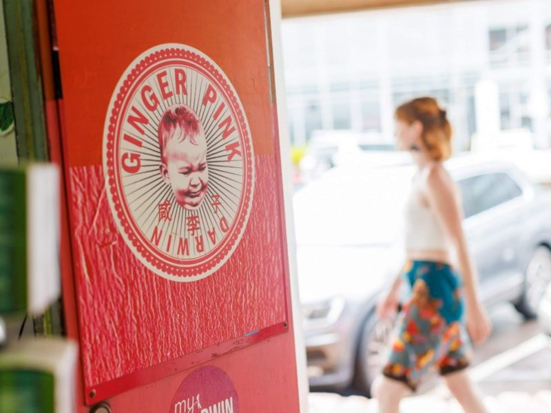 Woman walking past front of store with Ginger Pink logo in foreground