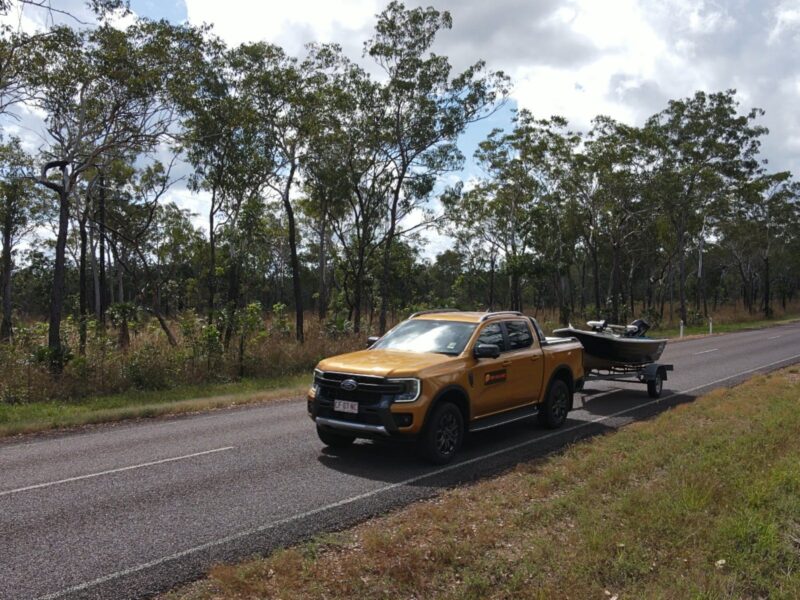 Yellow Ford Wildtrak towing a boat on a road in Darwin