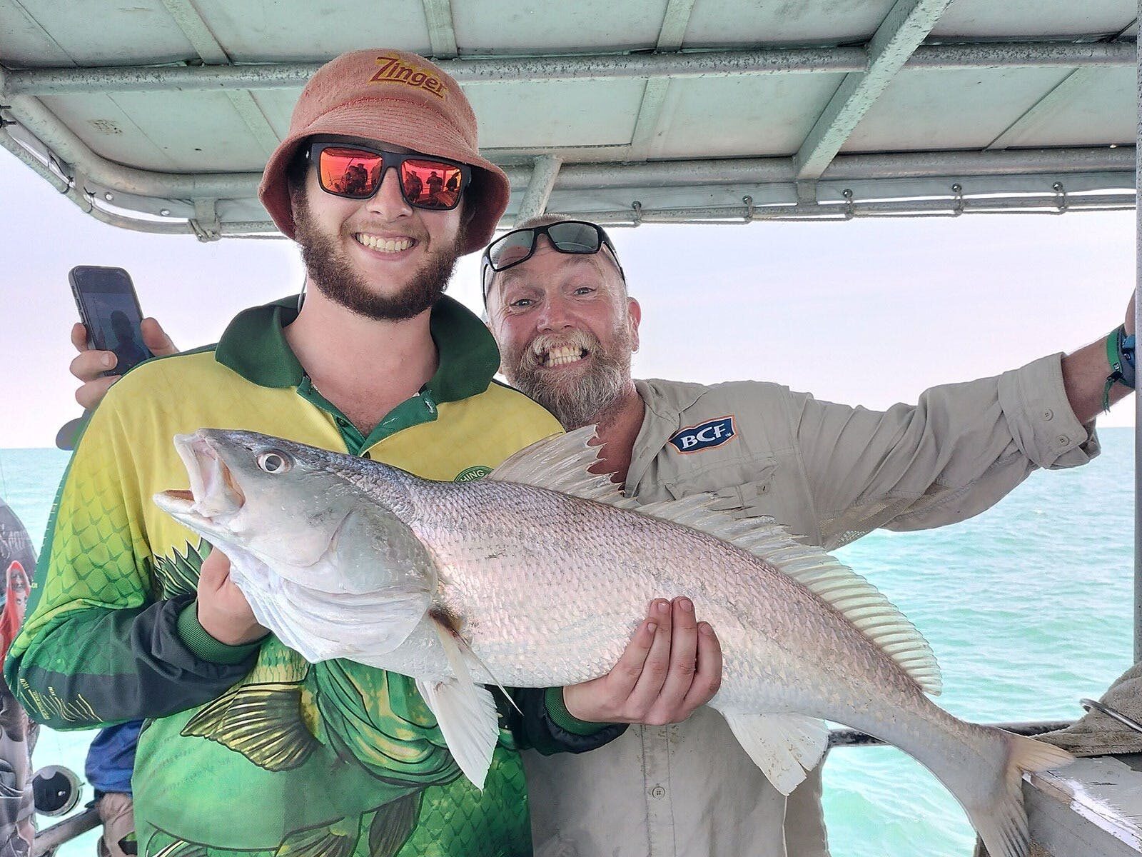 A man holding a fish on a Darwin Red Devil Charter.