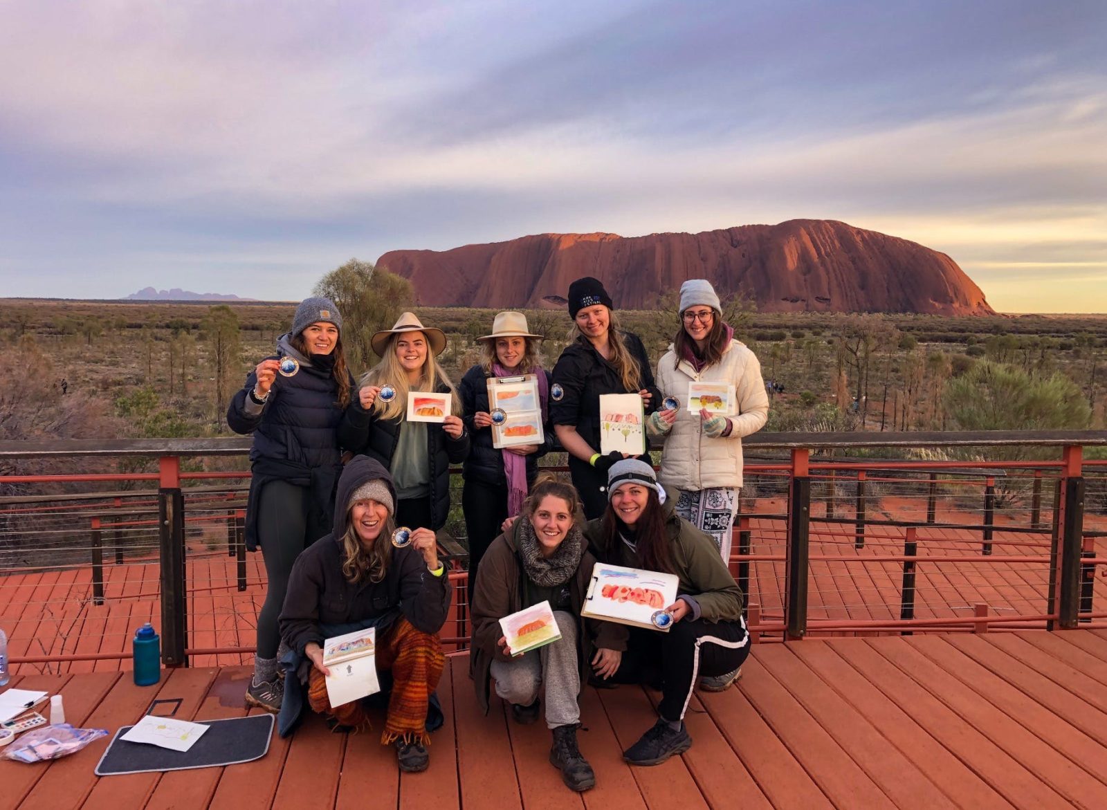 A group of people with paintings at Uluru