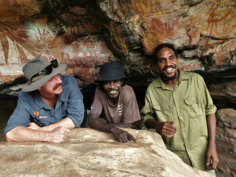Three Top End Guides in fron of spectacular Arnhem Land rock art