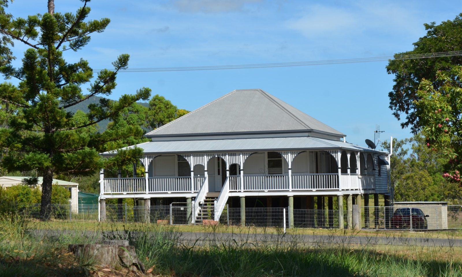 photo of an old Queensland style house with front stairs leading to a verandah across the house