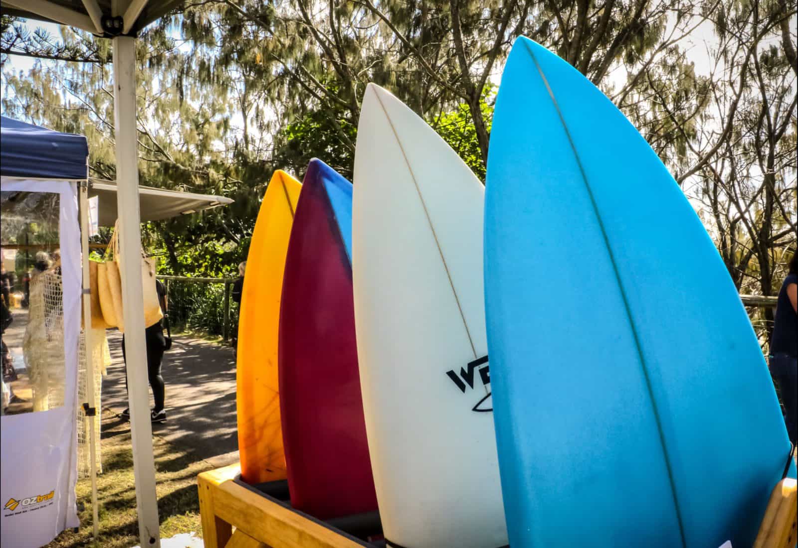 four brightly coloured surf boards on a hand made rack