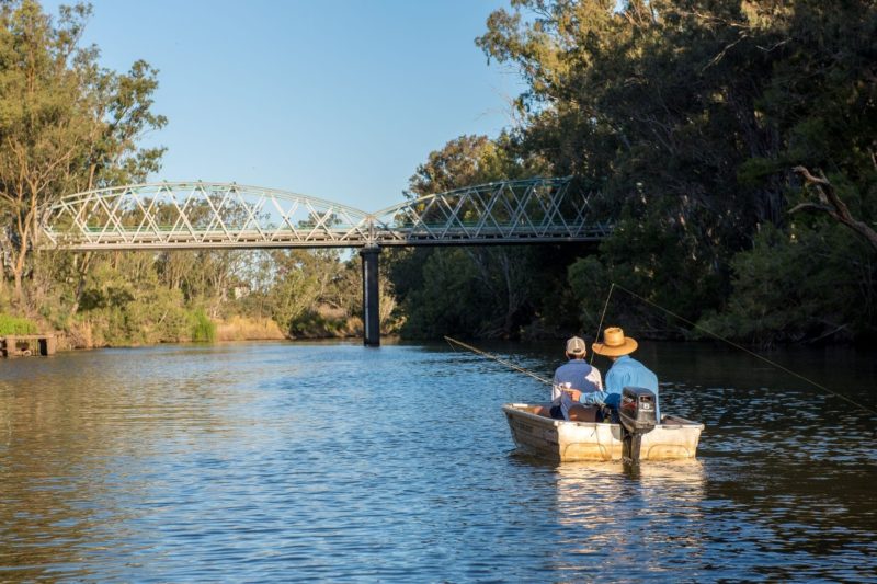 Fishing from a tinny on the Mcintryre River with Historic Border Bridge in the background
