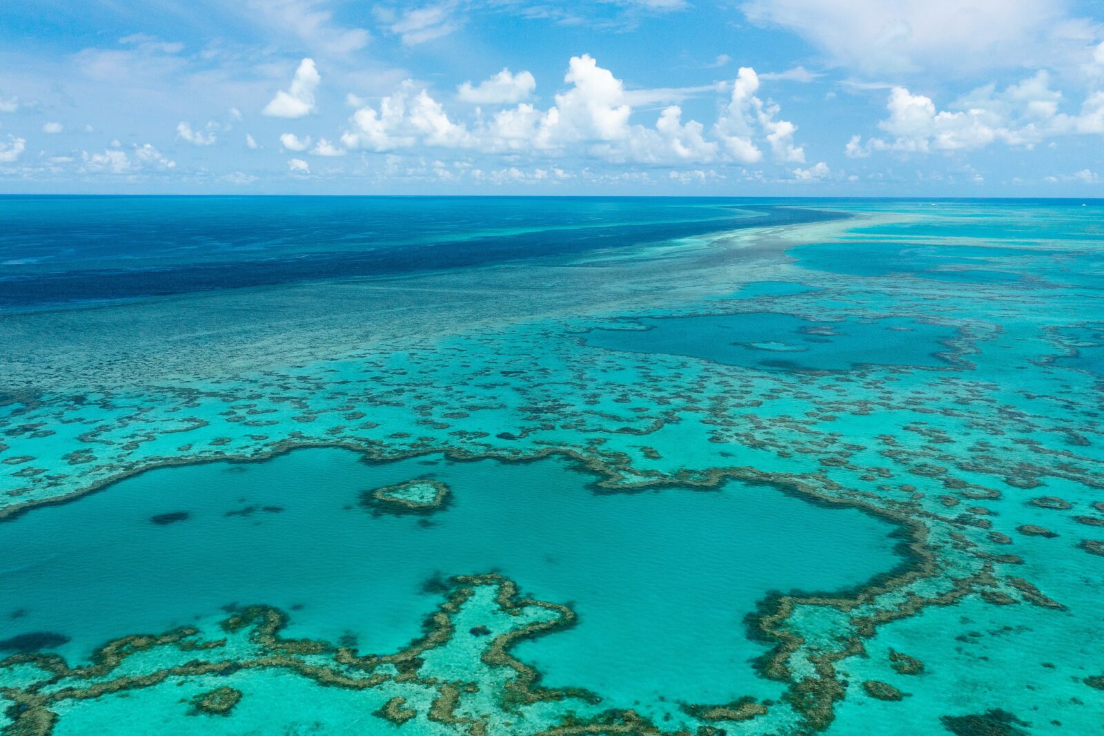 Aerial view of the calm turquoise waters and the endless reef during low ocean tide