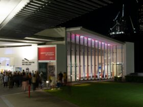 Exterior view of Griffith University Art Museum at nigh, with a large crowd