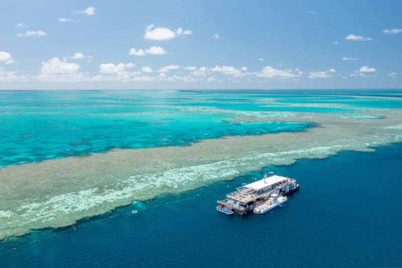 A big pontoon moored along the deep blue waters of the great barrier reef wall