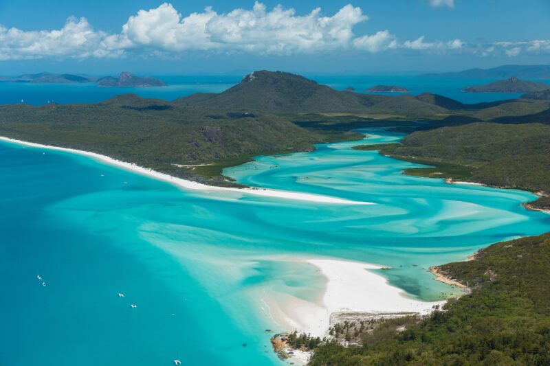Aerial view of the swirling fusion of white sand and turquoise water into the inlet