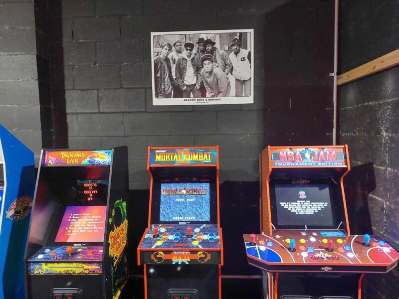 Picture of some 1UP arcade machines lined up against a wall