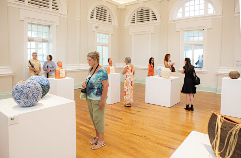 Visitors are looking at Yarrabah Ceramics exhibiton by Yarrabah Art Centre.