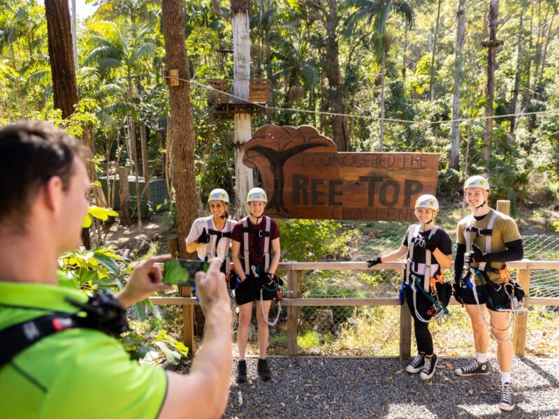 Group of climbers getting a photo infront of our TreeTop Challenge sign