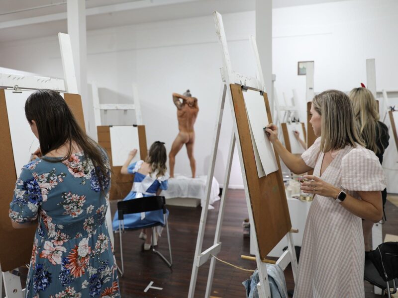 Hens' Party guests drawing a model in a live-drawing session in Umbrella's gallery in 2022.