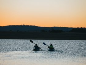 photo of two kayakers on Leslie Dam at sunset