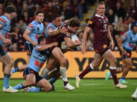 An image of Pat Carrigan being tackled by two NSW players while playing for Queensland