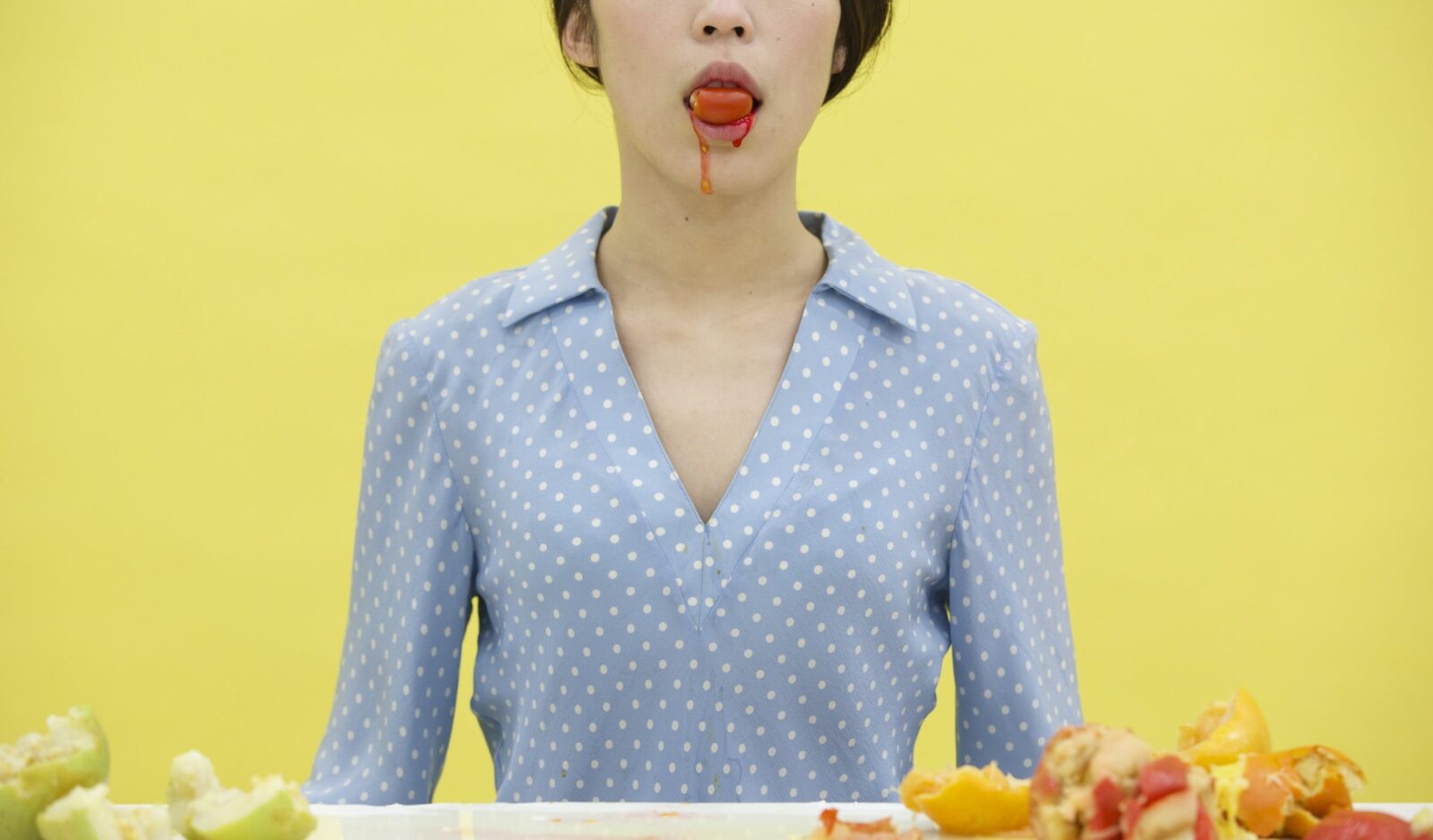 Image of lady in blue polka dot dress with a fruit juice substance drooling from her mouth.