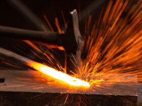 Hammer hitting metal with sparks flying.