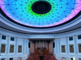 Organ is centred in the grand room, lit by a bright blue, green and pink ceiling light above