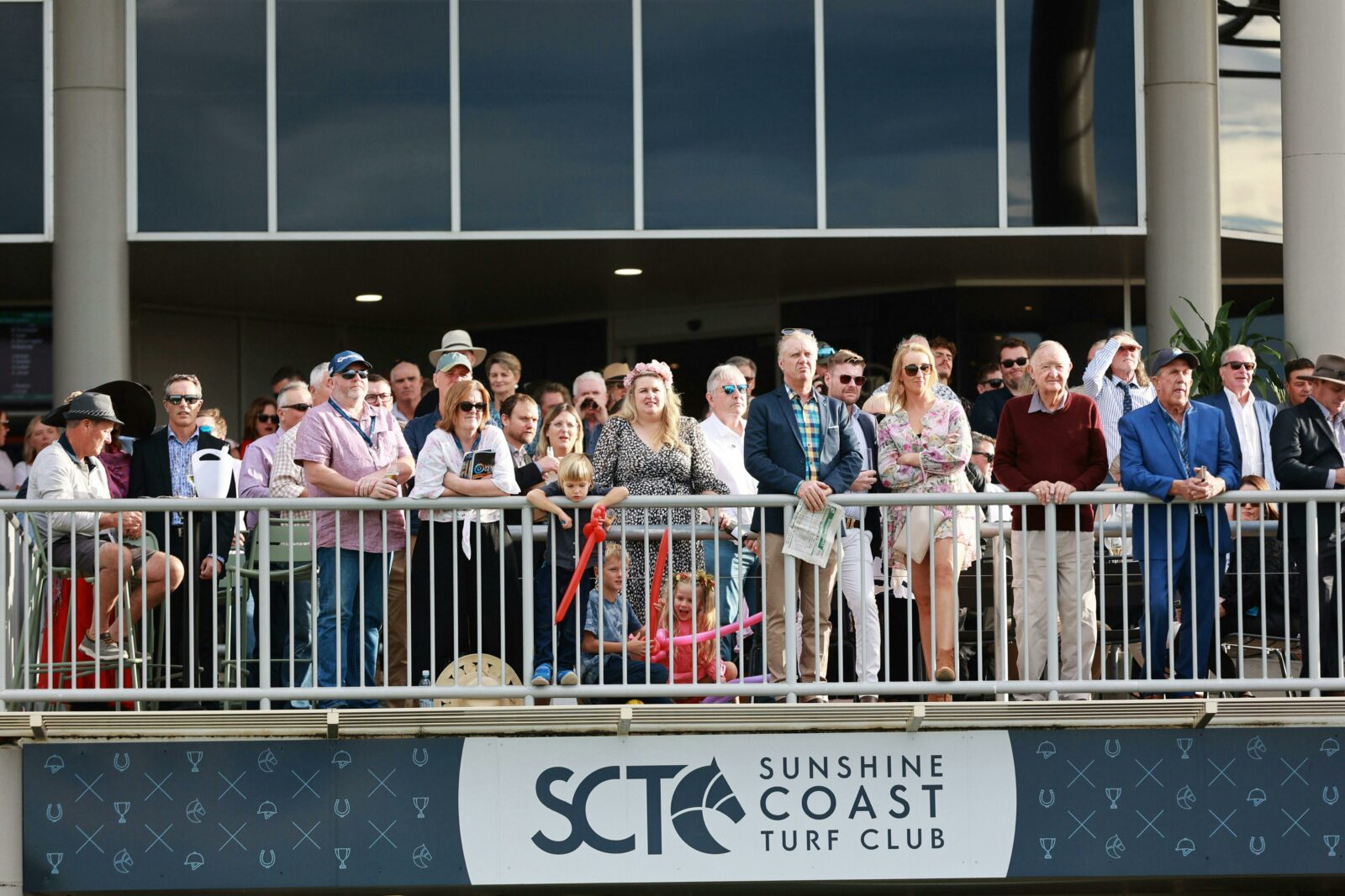 Crowd looking out onto the track from the outdoor members terrace